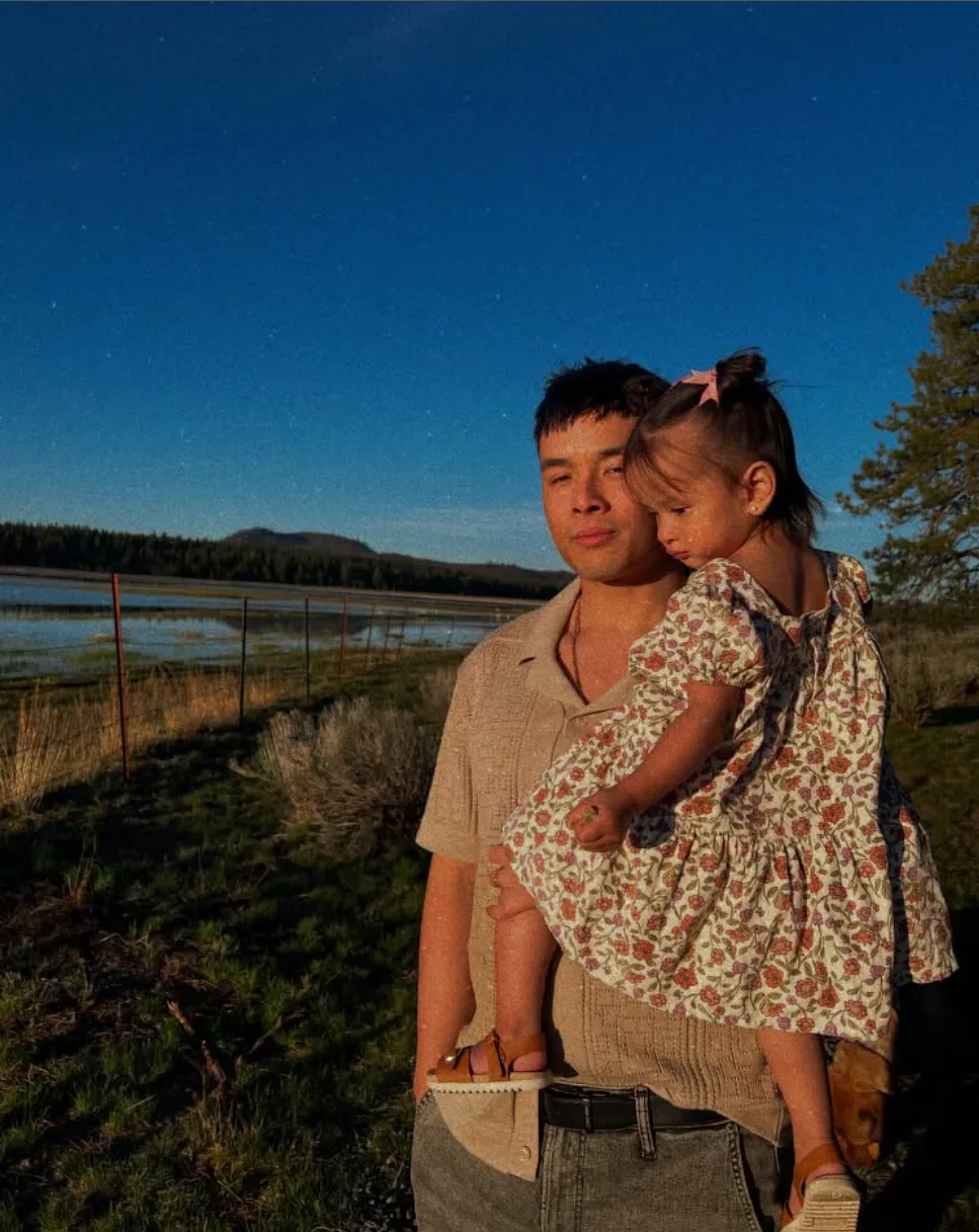 Steve Vo, who runs Motr, holding his daughter at dusk in the Oregon mountains